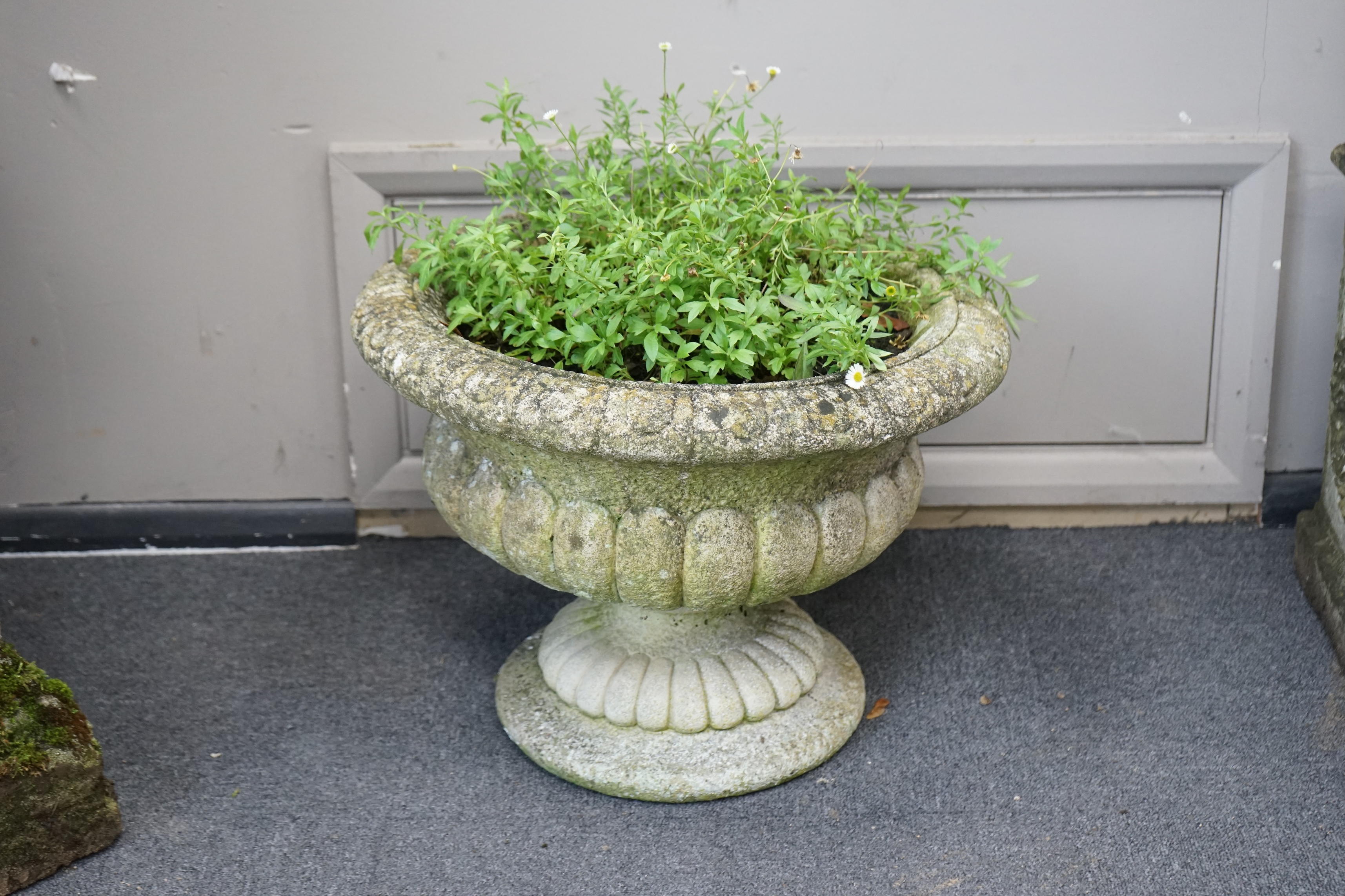 A pair of reconstituted stone circular garden urns